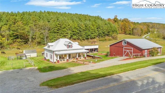 an aerial view of residential houses with outdoor space and trees