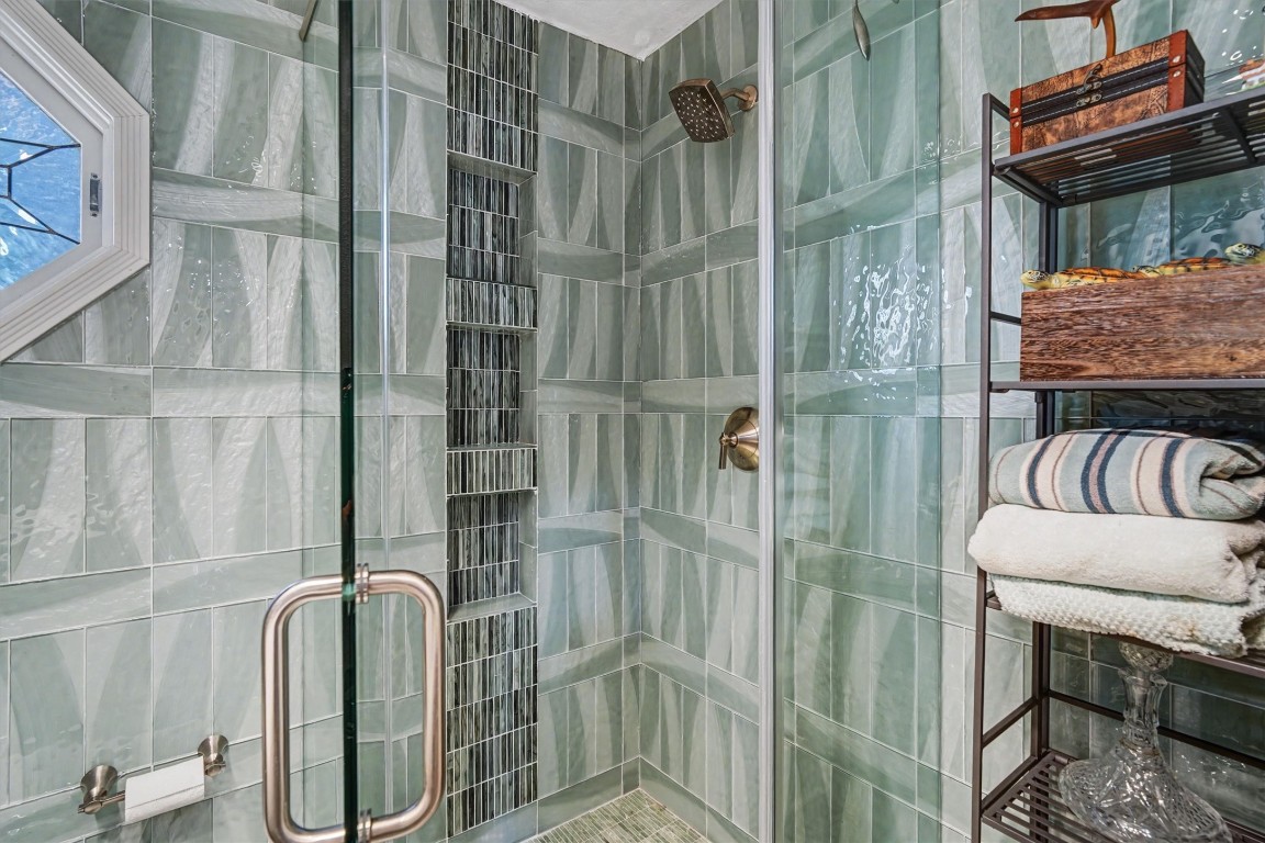 2205 Mission Street Kemah, TX 77565 - Photo 13 of 33 Elegant walk-in shower with custom tile work and built-in niche shelving for convenience and style.