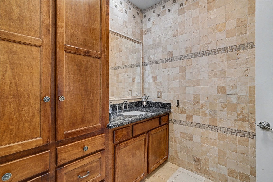2205 Mission Street Kemah, TX 77565 - Photo 19 of 33 a bathroom with a granite countertop sink a toilet and shower