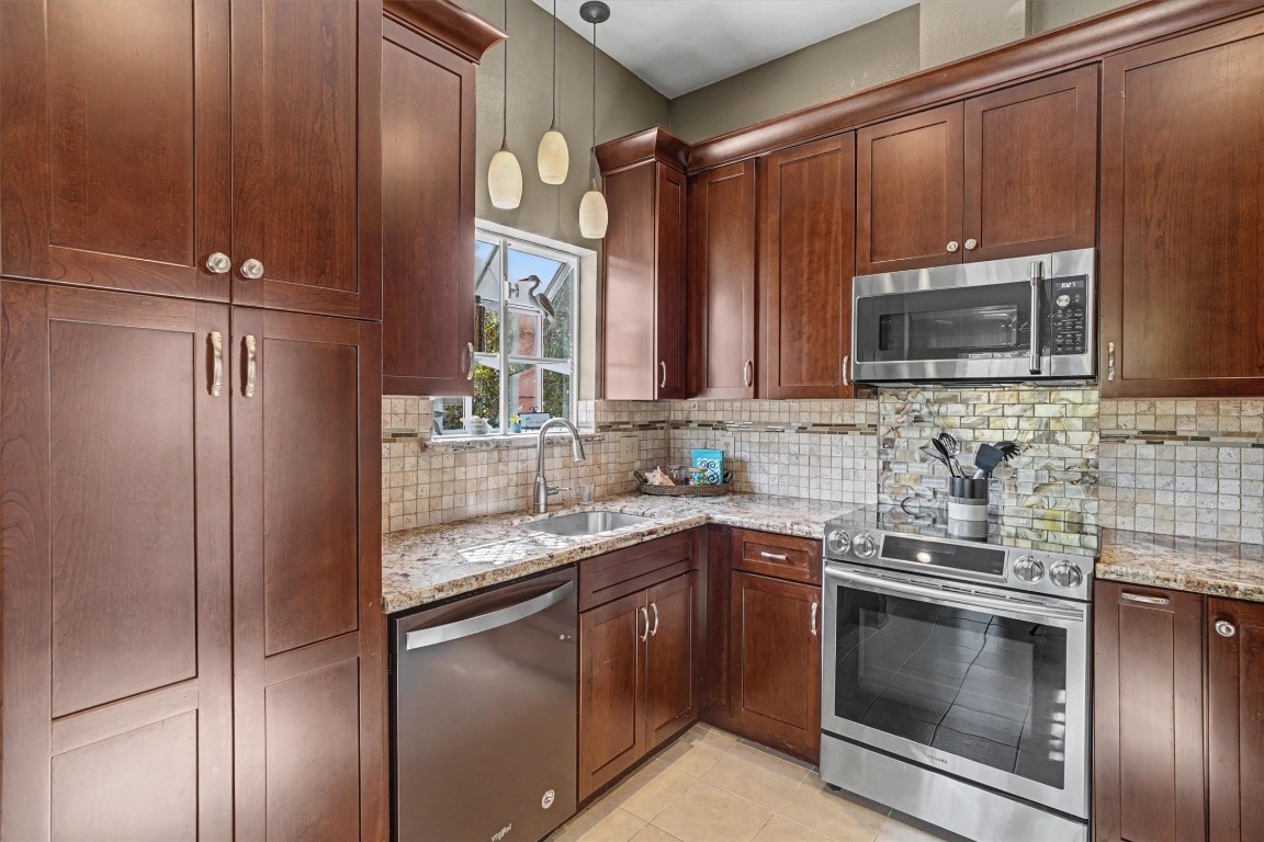 2205 Mission Street Kemah, TX 77565 - Photo 8 of 33 a kitchen with stainless steel appliances granite countertop a sink stove and refrigerator
