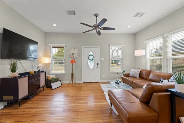 a living room with furniture and a wooden floor