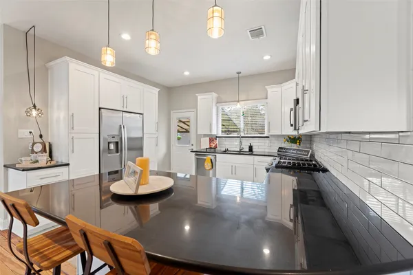 a kitchen with stainless steel appliances granite countertop a sink a stove and cabinets