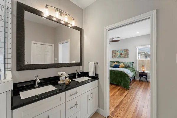 a bathroom with a granite countertop toilet sink and mirror