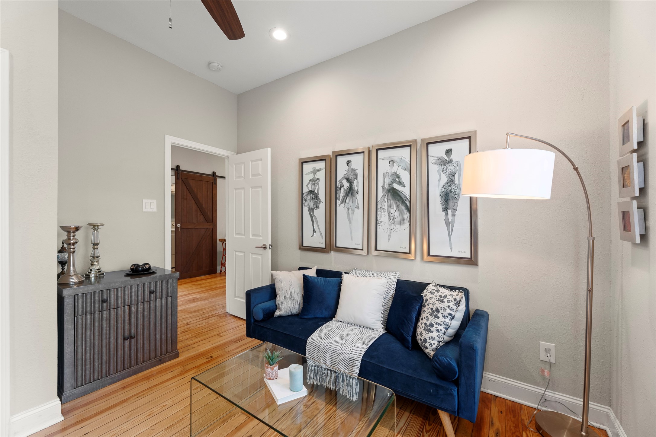 711 4th Street Sealy, TX 77474 - Photo 29 of 37 Lovely room space features warm wood floors adding charm, while a sleek floor lamp provides soft lighting.