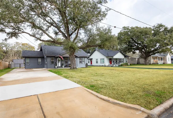 a front view of a house with a garden and trees