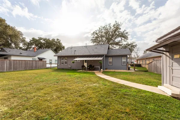 a backyard of a house with plants and wooden fence