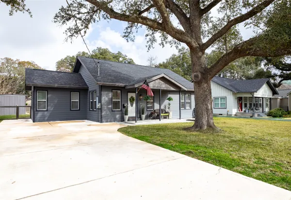 a front view of a house with a garden and trees