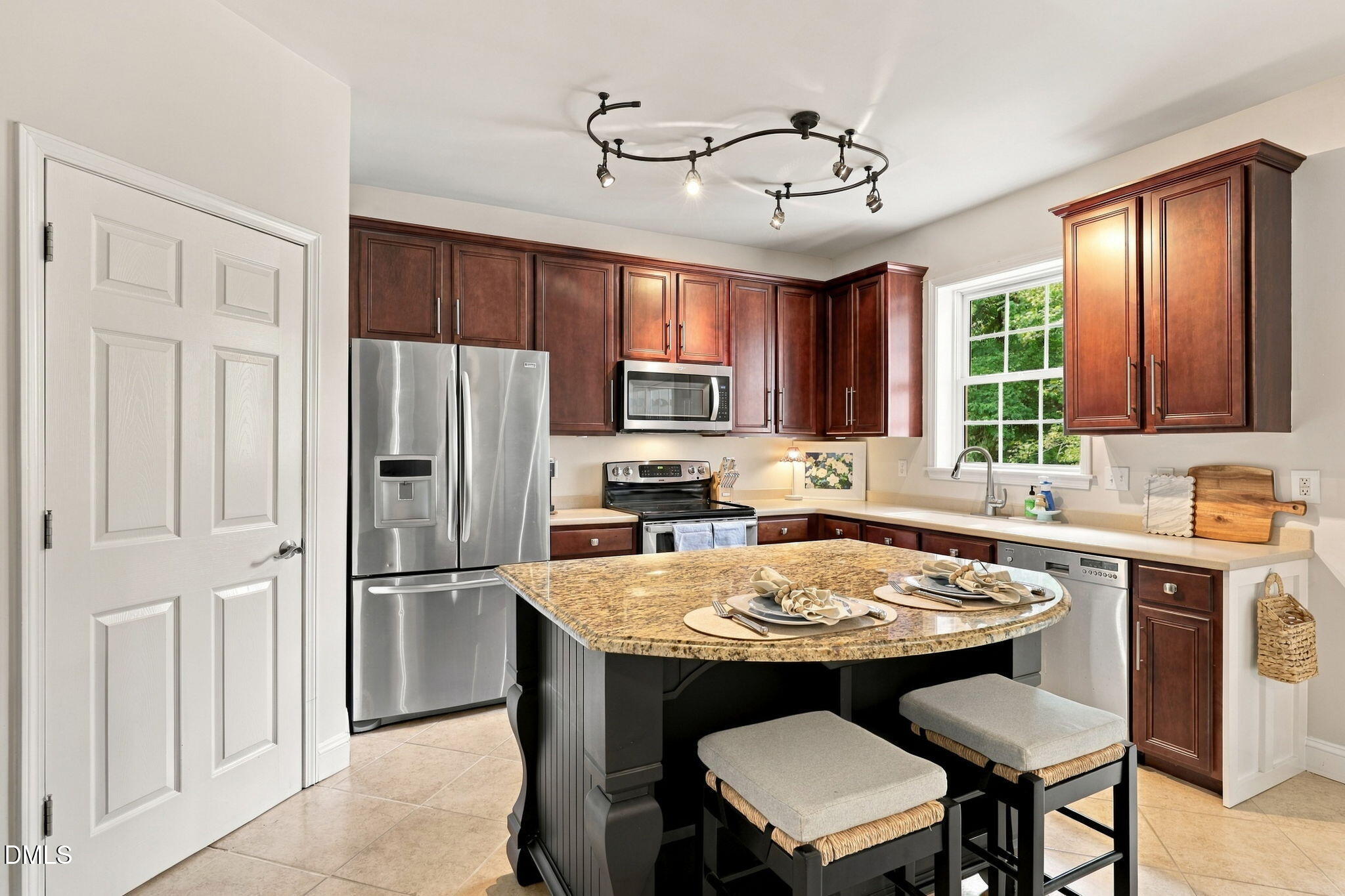 6 Sydenham Road Durham, NC 27713 - Photo 9 of 44 Gorgeous kitchen showcasing rich wood cabinetry, stainless steel appliances including a French-door refrigerator and built-in microwave, granite-style countertops, and an island with seating