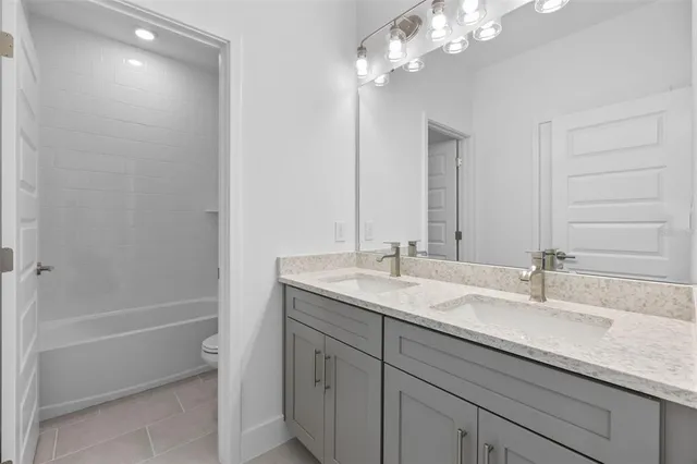 a bathroom with a granite countertop sink a toilet and shower