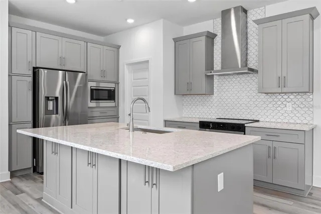 a kitchen with stainless steel appliances a sink a stove a refrigerator and cabinets