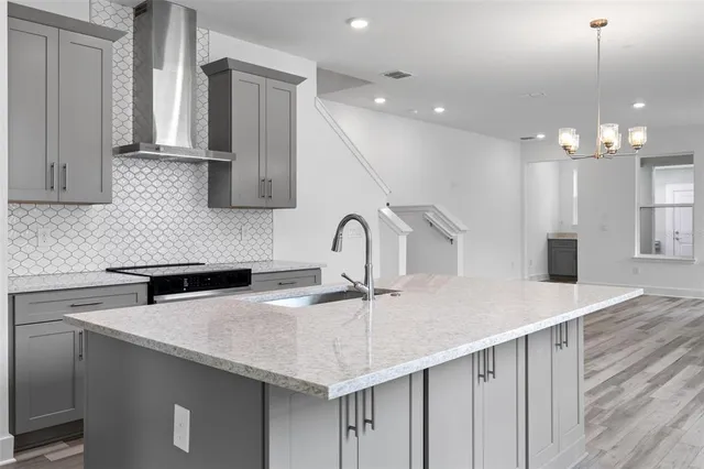 a kitchen with granite countertop a sink cabinets and stainless steel appliances