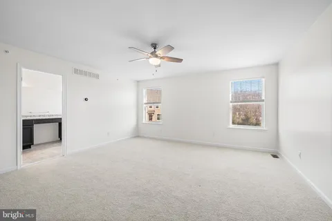 a view of a big room with chandelier fan and windows