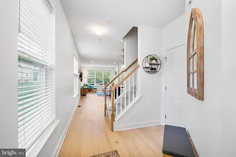 a view of entryway and hall with wooden floor