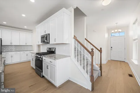 a kitchen with white cabinets stainless steel appliances and a sink