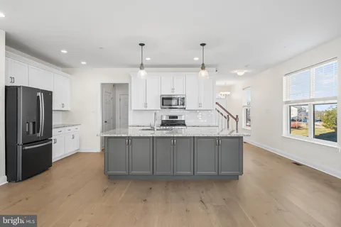 a large kitchen with granite countertop a large counter top stainless steel appliances and cabinets