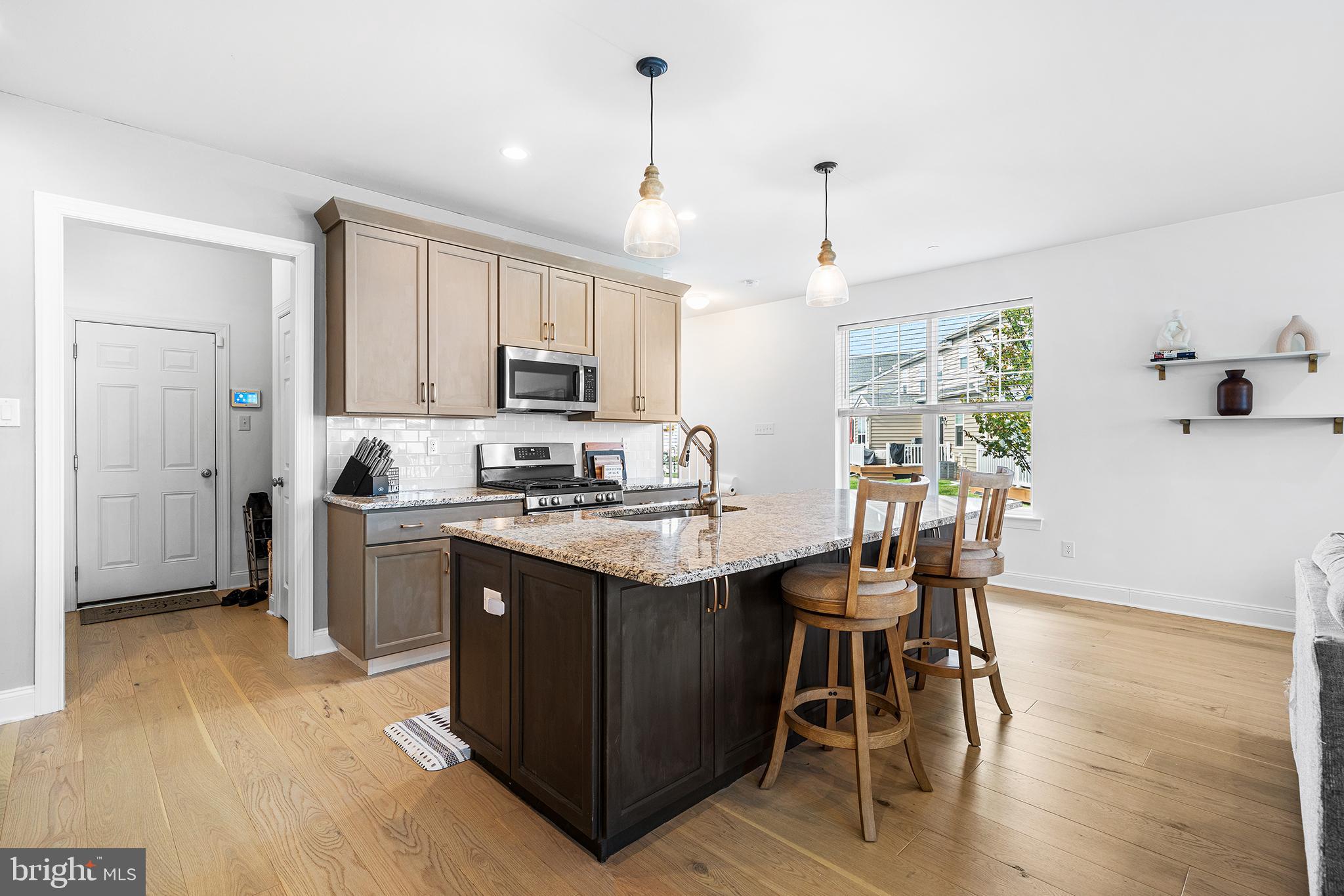 186 Spring Lane Royersford, PA 19468 - Photo 8 of 29 a kitchen with stainless steel appliances granite countertop a stove top oven a refrigerator a sink and a dining table with wooden floor