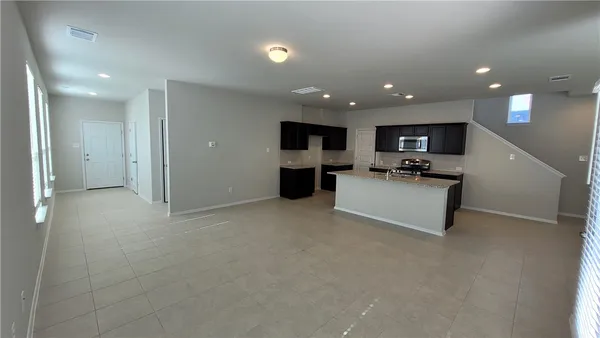 a view of kitchen with refrigerator stove microwave and cabinets