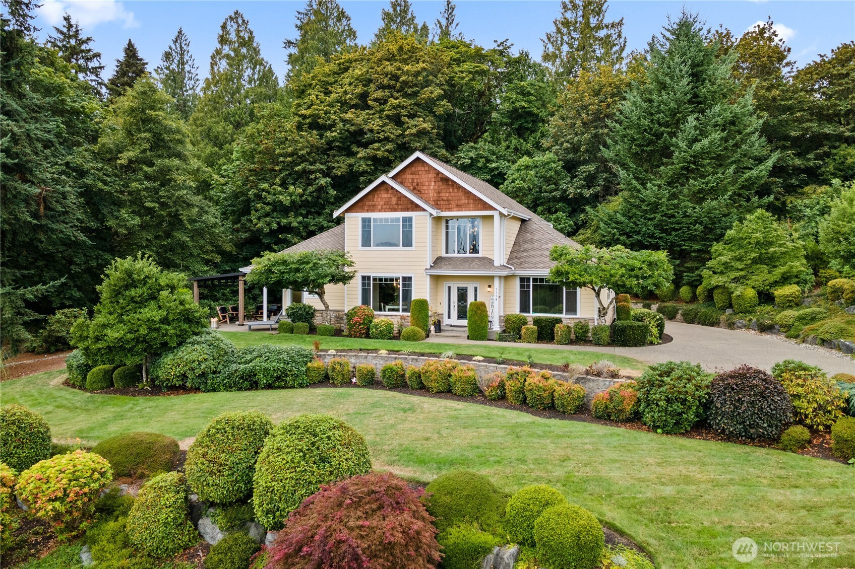 a front view of a house with a yard and green space