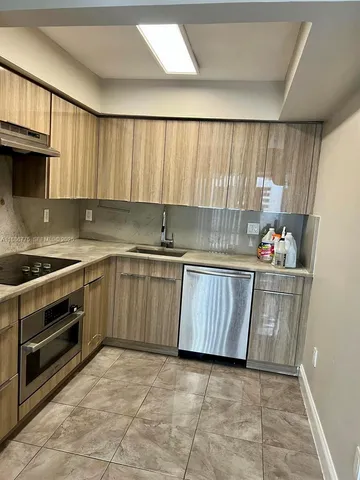a kitchen with a sink a stove and cabinets
