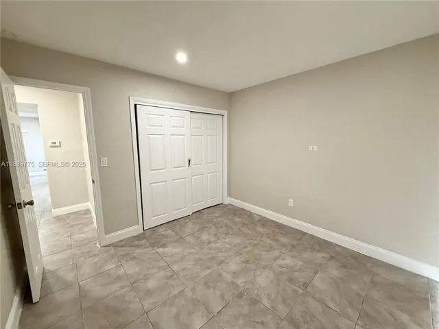 an empty room with a mirror and a sink