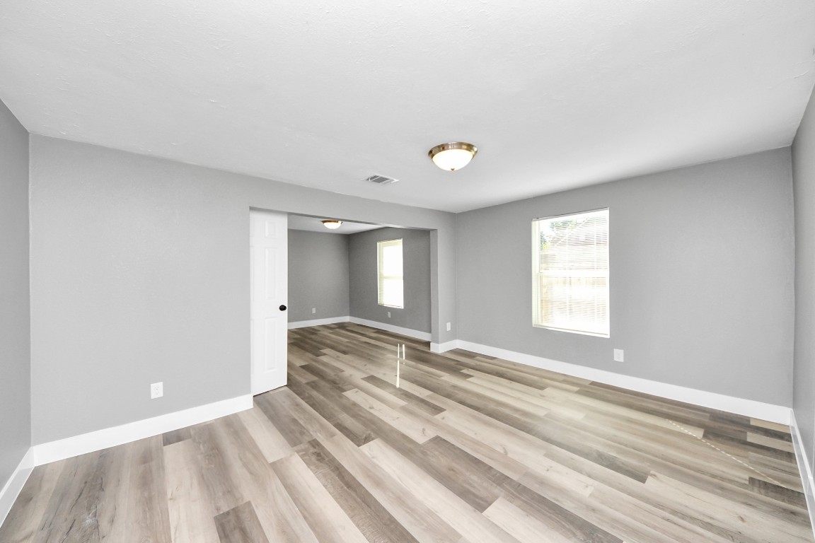 3206 Melbourne Street Houston, TX 77026 - Photo 16 of 41 a view of an empty room with wooden floor and a window