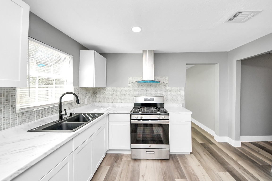 3206 Melbourne Street Houston, TX 77026 - Photo 26 of 41 a kitchen with a stove a sink and a window
