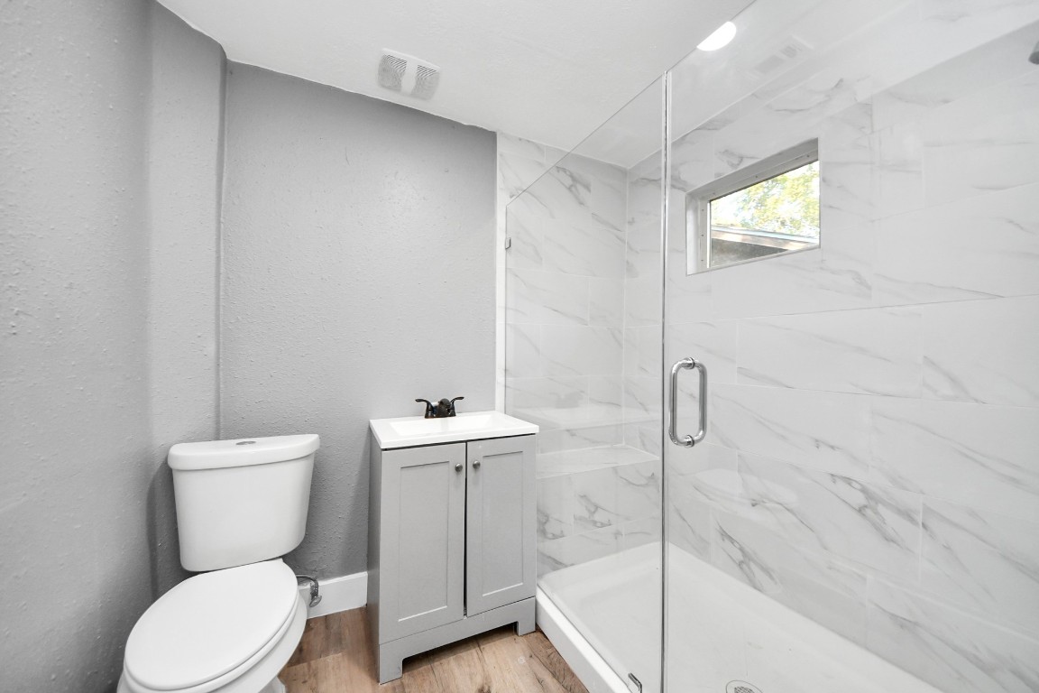 3206 Melbourne Street Houston, TX 77026 - Photo 35 of 41 a bathroom with a toilet a sink and mirror