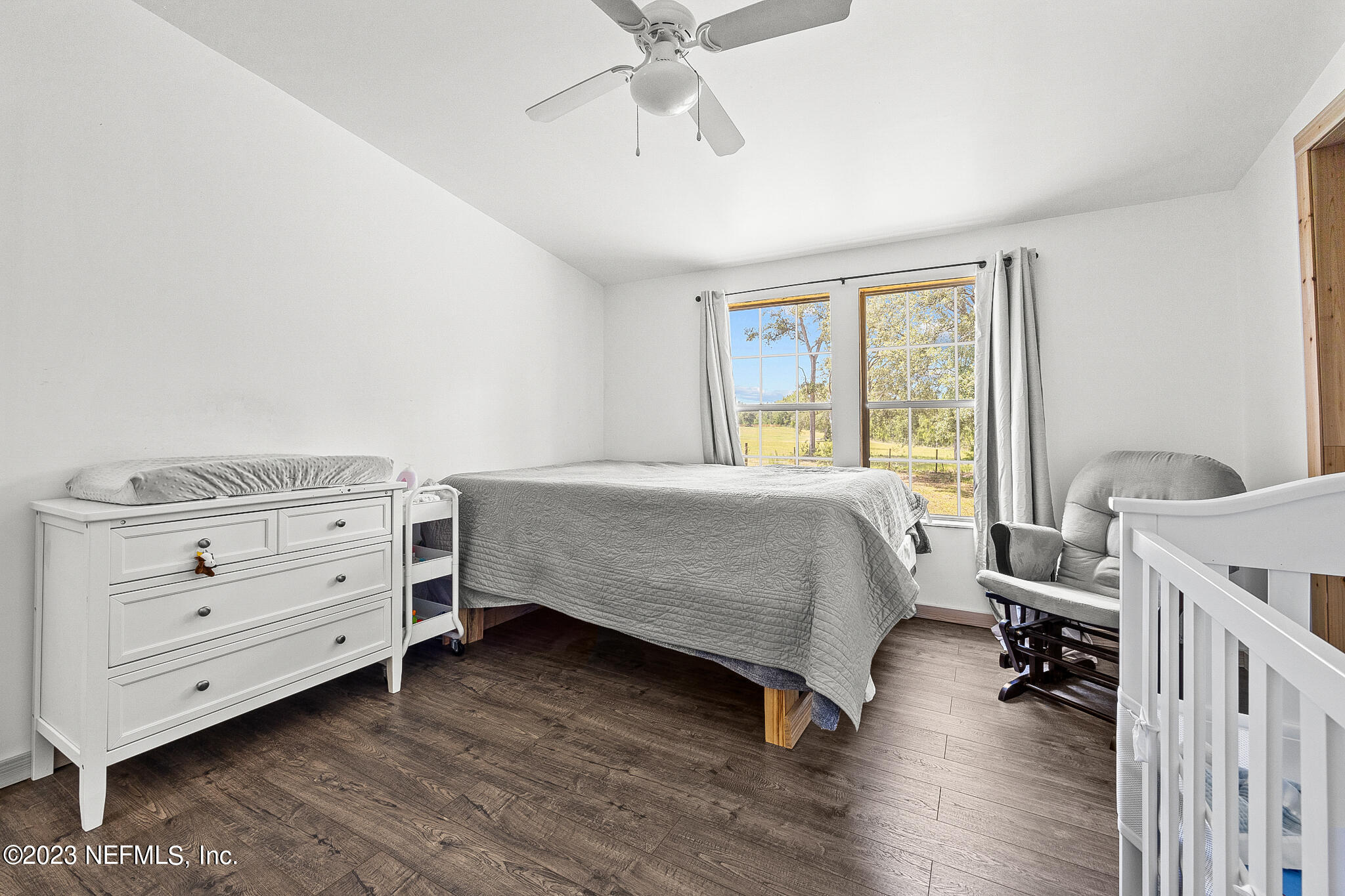 7730 Ranchette Road Keystone Heights, FL 32656 - Photo 18 of 30 a bedroom with a bed and a chandelier