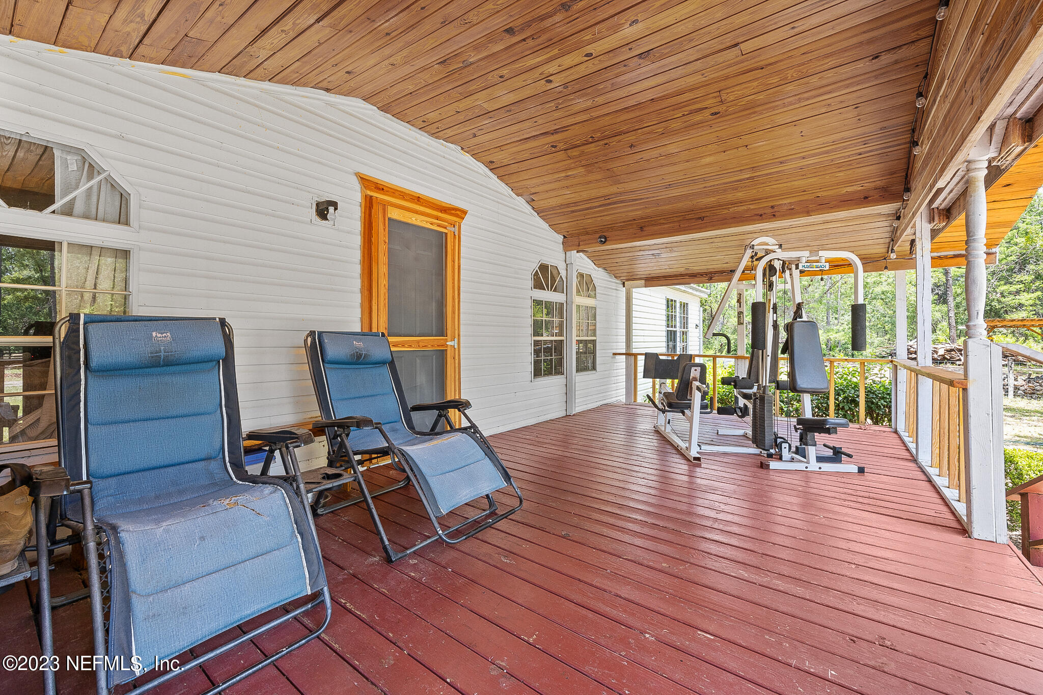 7730 Ranchette Road Keystone Heights, FL 32656 - Photo 19 of 30 a view of a patio with table and chairs with wooden floor and fence