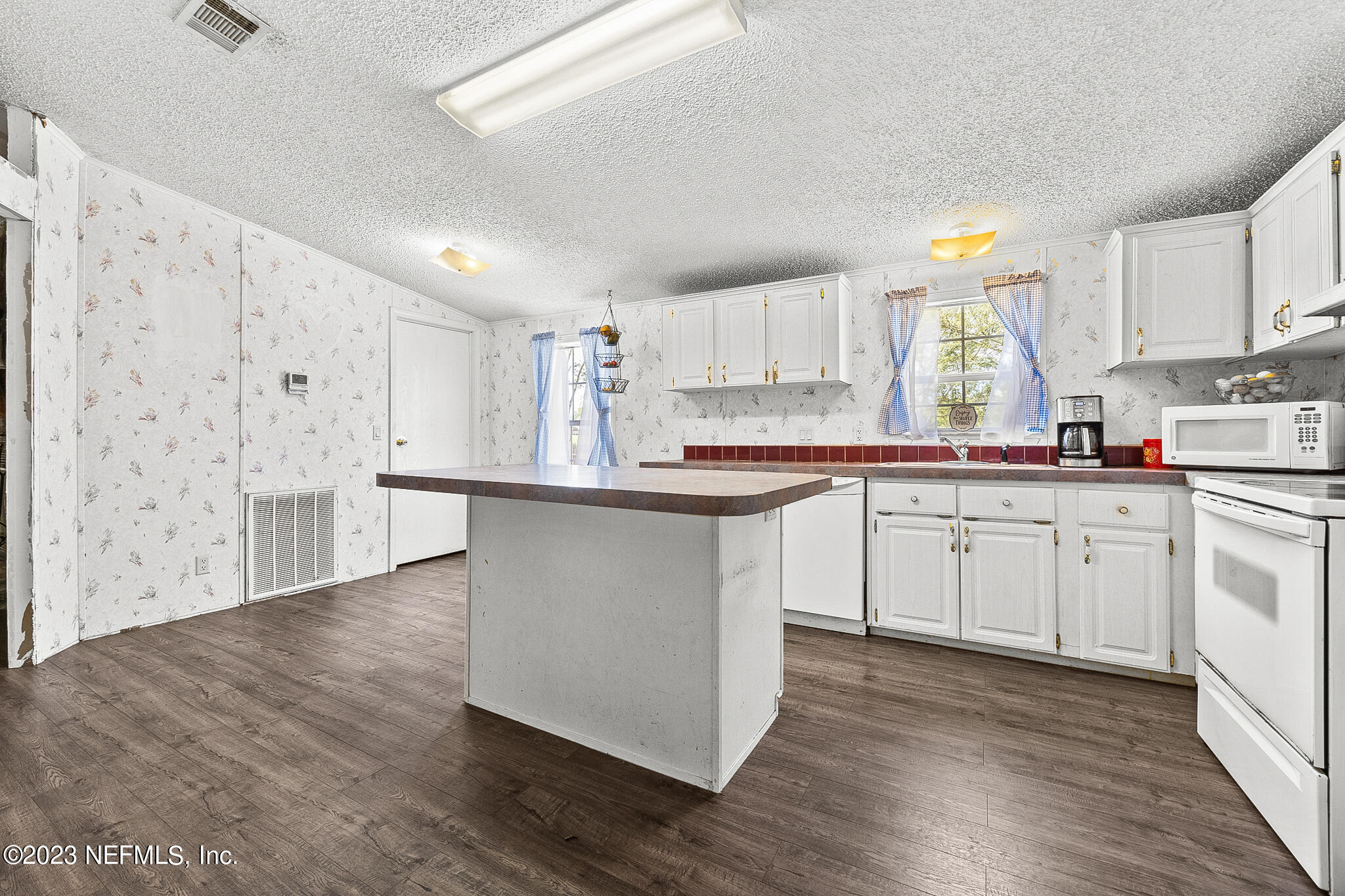7730 Ranchette Road Keystone Heights, FL 32656 - Photo 7 of 30 a kitchen with stainless steel appliances granite countertop a sink cabinets and wooden floor