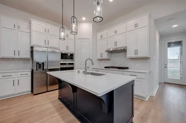 a kitchen with stainless steel appliances granite countertop a sink stove and refrigerator