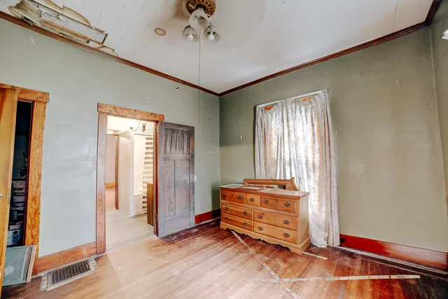 a view of a livingroom with wooden floor and a ceiling fan