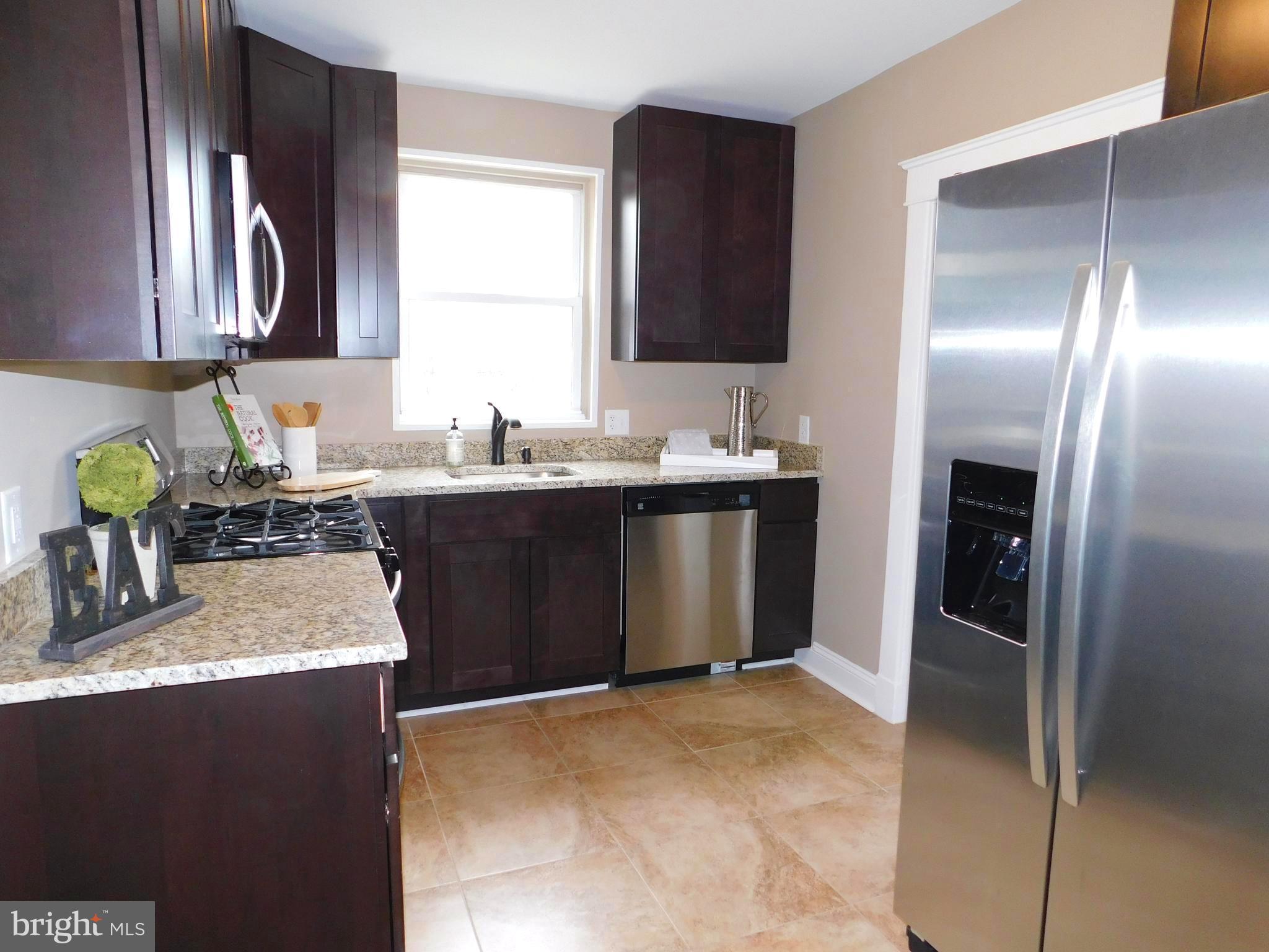606 Andover Road Linthicum, MD 21090 - Photo 11 of 29 a kitchen with stainless steel appliances granite countertop a sink stove and refrigerator