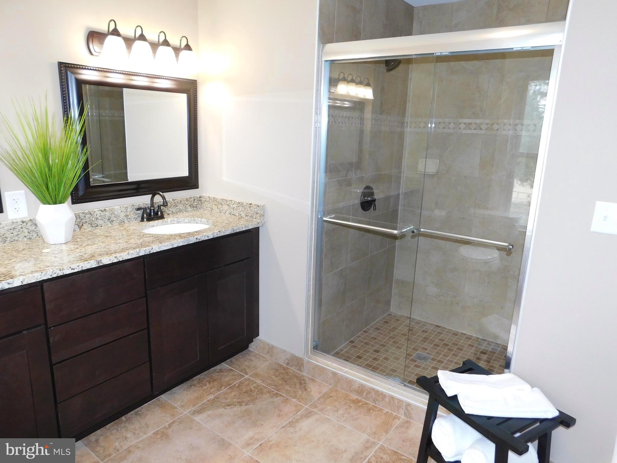 606 Andover Road Linthicum, MD 21090 - Photo 19 of 29 a bathroom with a granite countertop sink a mirror and shower