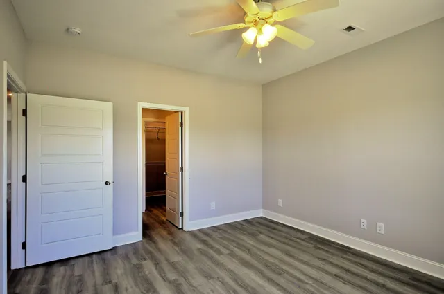 a view of an empty room with closet and a chandelier fan