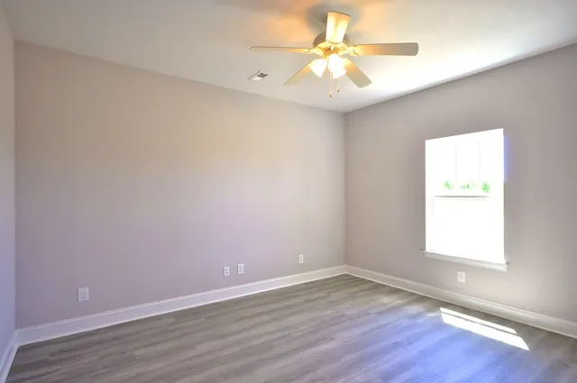 an empty room with a window and a fan