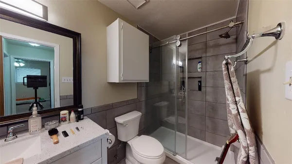a bathroom with a sink a toilet and shower