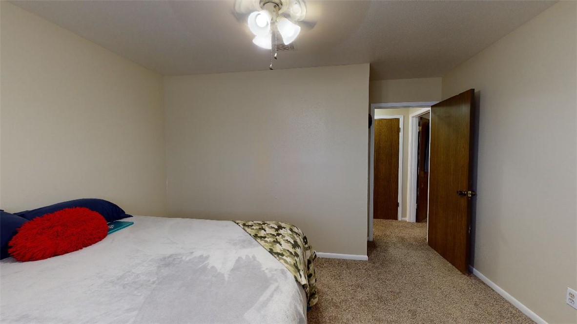 1809 Treehouse Trail, Unit D College Station, TX 77845 - Photo 18 of 23 a bedroom with a bed and a chandelier