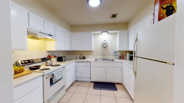 a kitchen with a sink a refrigerator and cabinets