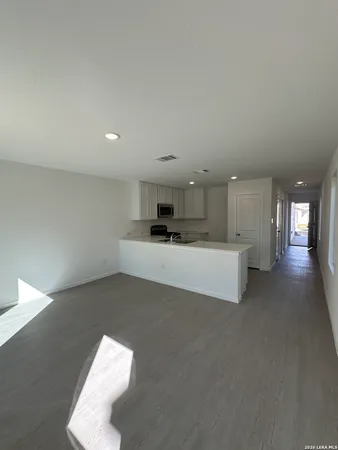 a living room with stainless steel appliances kitchen island furniture and a fireplace