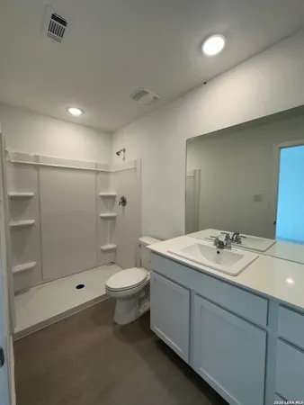 a bathroom with a sink a toilet and shower