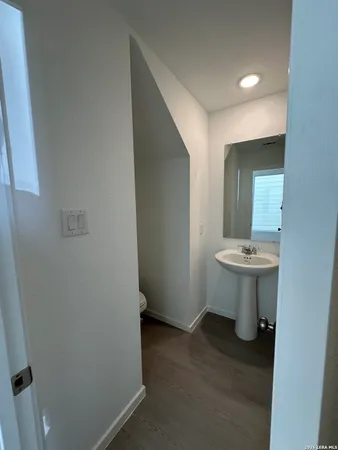 a bathroom with a sink a toilet and mirror