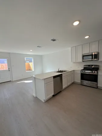 a kitchen with stainless steel appliances a refrigerator and a stove top oven