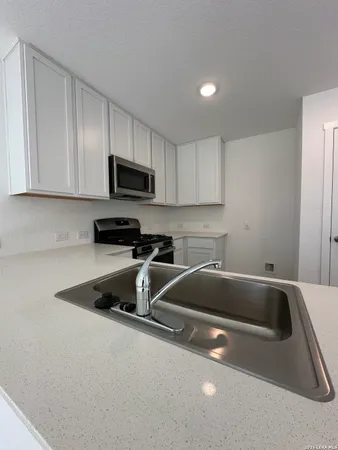 a kitchen with a sink a microwave and cabinets