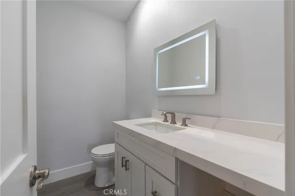 a bathroom with a toilet sink vanity and mirror