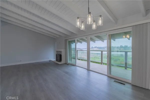 a view of an empty room with wooden floor and a floor to ceiling window