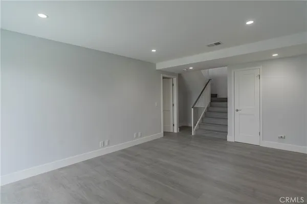 an empty room with wooden floor and stairs