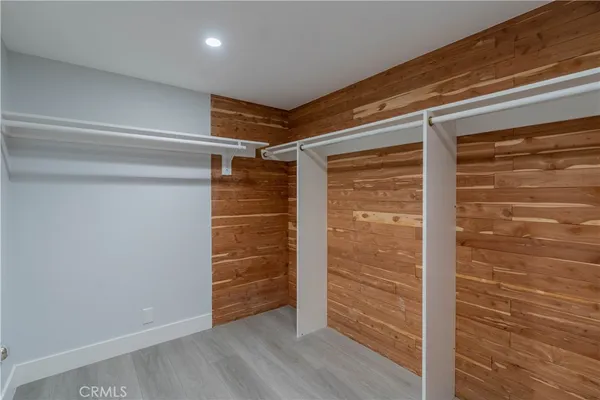 a view of walk in closet with wooden floor