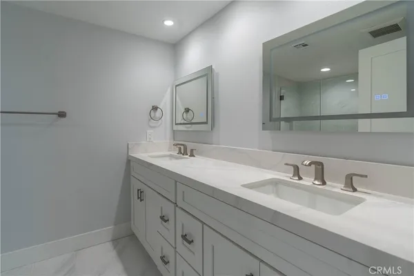 a bathroom with a double vanity sink and a mirror