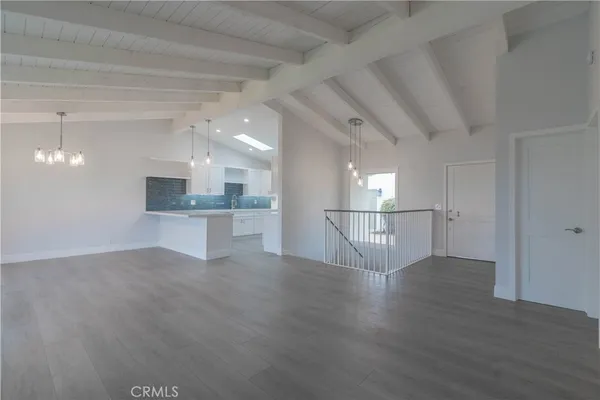 a view of a kitchen with a sink and an empty room